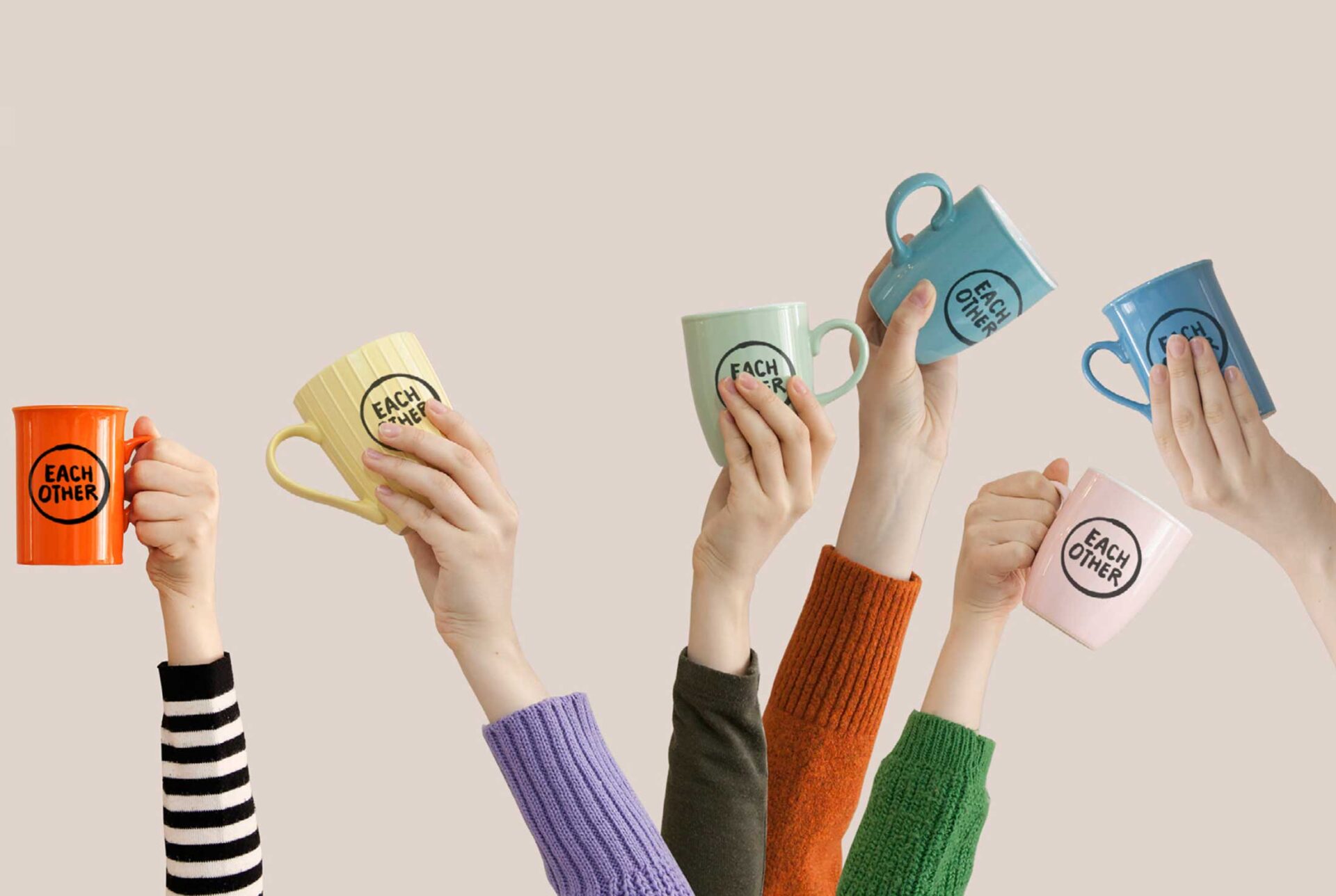 Lots of different arms in the air and hands holding different coloured mugs with the EachOther logo on them